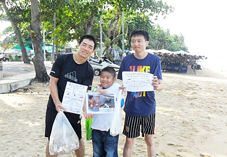 Two Chinese gentlemen and Phu are helping to clean trash off Jomtien Beach.